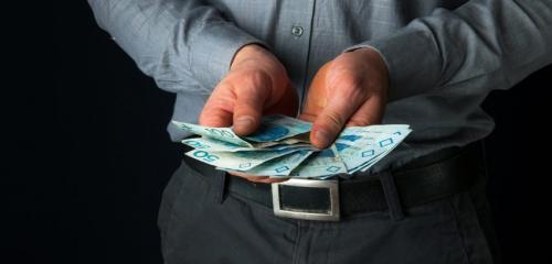mężczyzna trzymający w dłoniach banknoty