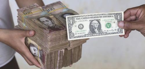 jeden dolar amerykański na tle bloku banknotów wenezuelskich