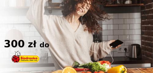 kobieta tańcząca w kuchni ze smartfonem w dłoni