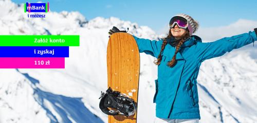 kobieta w niebieskiej kurtce z deską snowboardową