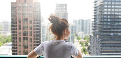 Zadowolona z życia młoda kobieta patrzy przed balkon