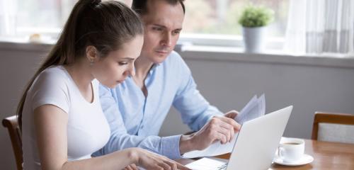 Kobieta i mężczyzna sprawdzają w internecie różnice między kredytem a pożyczką