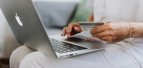 Kobieta z laptopem na kolanach aktywująca kartę w mBanku
