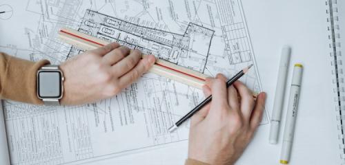 Architekt z linijką i ołówkiem sprawdzający wypis i wyrys z rejestru gruntów