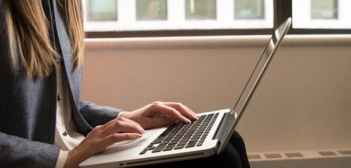 kobieta siedząca przed otwartym laptopem sprawdzająca, jak zamknąć konto w banku pekao s.a.