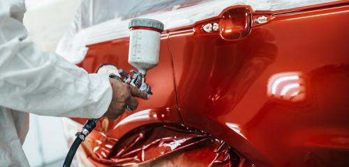 Lakiernik w trakcie malowania samochodu