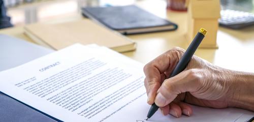 Osoba podpisuje dokument przepisania mieszkania u notariusza