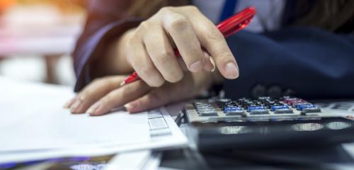 Kobieta liczy na kalkulatorze czy może szybko spłacić kredyt