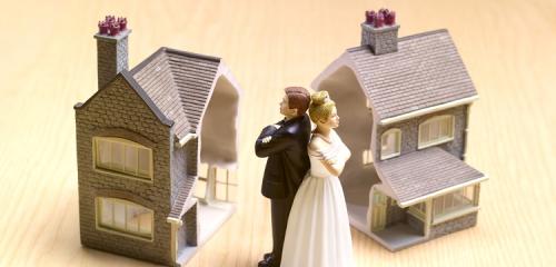 figurki pary małżeńskiej stojącej do siebie plecami i podzielony na pół model domu