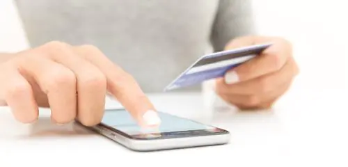 kobieta ze smartfonem wprowadzająca do Apple Pay dane karty płatniczej
