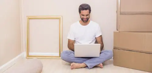 mężczyzna z laptopem siedzący na podłodze