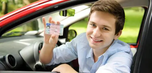 młody chłopak z prawem jazdy w samochodzie
